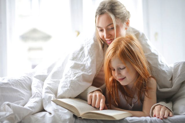 mother and daughter reading book together