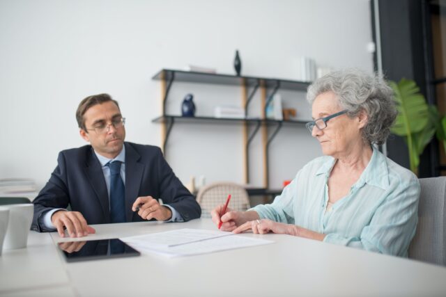 woman sitting with man reviewing documents